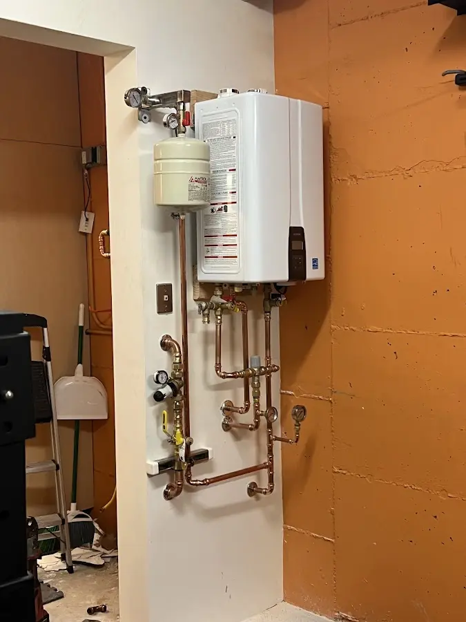 Plumbing technician inspecting water heater connections in Prairie du Chien